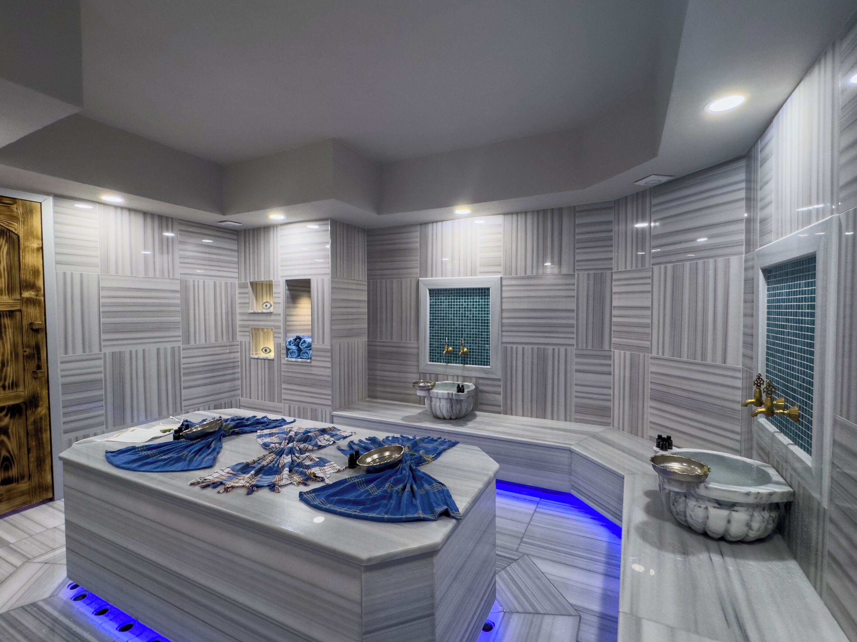 A modern bathroom with a large central bathtub, a separate shower area, and a vanity with a sink.