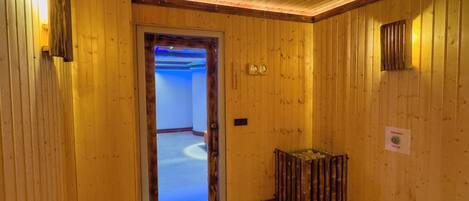 Un interior de madera con una puerta que conduce a una habitación con techo iluminado en azul.