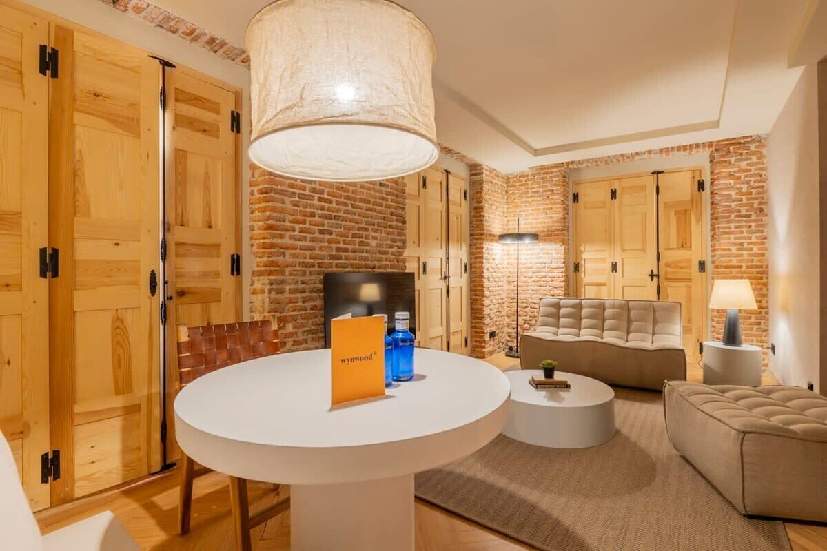 Un hall d’hôtel moderne avec une table ronde blanche, un canapé et une lampe.