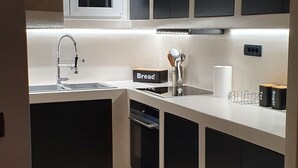 Una cuina moderna amb rentaplats integrat, un rentamics i una finestra sobre la taulell.