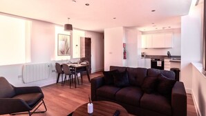 Un salon moderne comprenant un canapé, une table basse et un coin repas avec des chaises et une table.