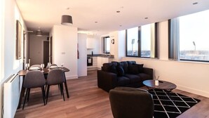 Un salon moderne avec un coin repas, un canapé et une cuisine en arrière-plan.