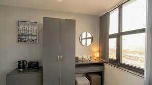 A modern kitchen with grey cabinets, a round mirror, a kettle, and a toaster on the counter. - Convenient Budget Sunderland Studio with Views (Sunderland)