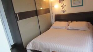 Ein ordentlich bezogenes Bett mit weißen Laken in einem Hotelzimmer.