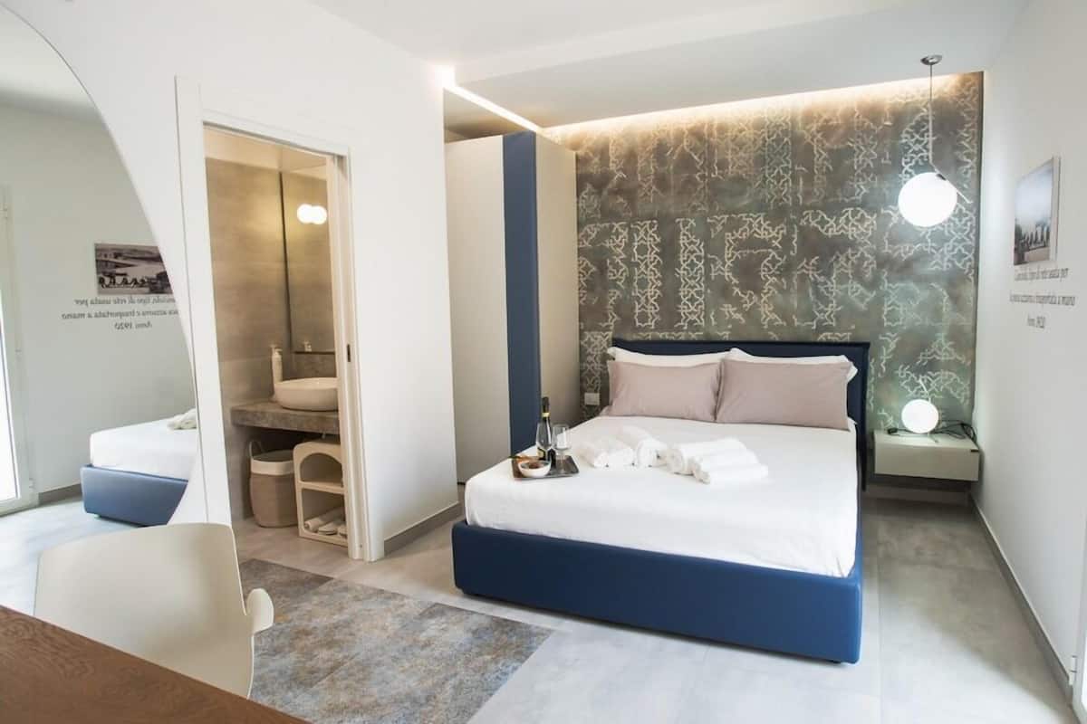 Une chambre d’hôtel moderne dotée d’un grand lit, d’un coin salon et d’une petite table avec des commodités.