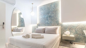 A modern bedroom with a large bed, a bedside table with a lamp, and a wall with a decorative pattern.
