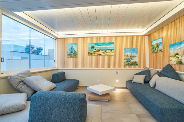 Una sala de estar moderna con un conjunto de sofás, una mesa de centro y obras de arte en las paredes.