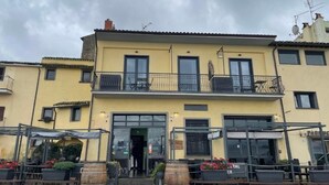 Un bâtiment jaune doté d’un balcon, d’une terrasse et d’une enseigne sur laquelle on peut lire « PARIS ».