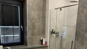 Une salle de bain moderne avec une douche à parois de verre, des toilettes et un lavabo.