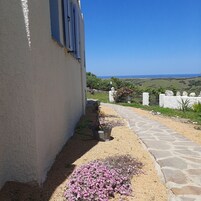 Un camino que lleva a un edificio con vista al mar.