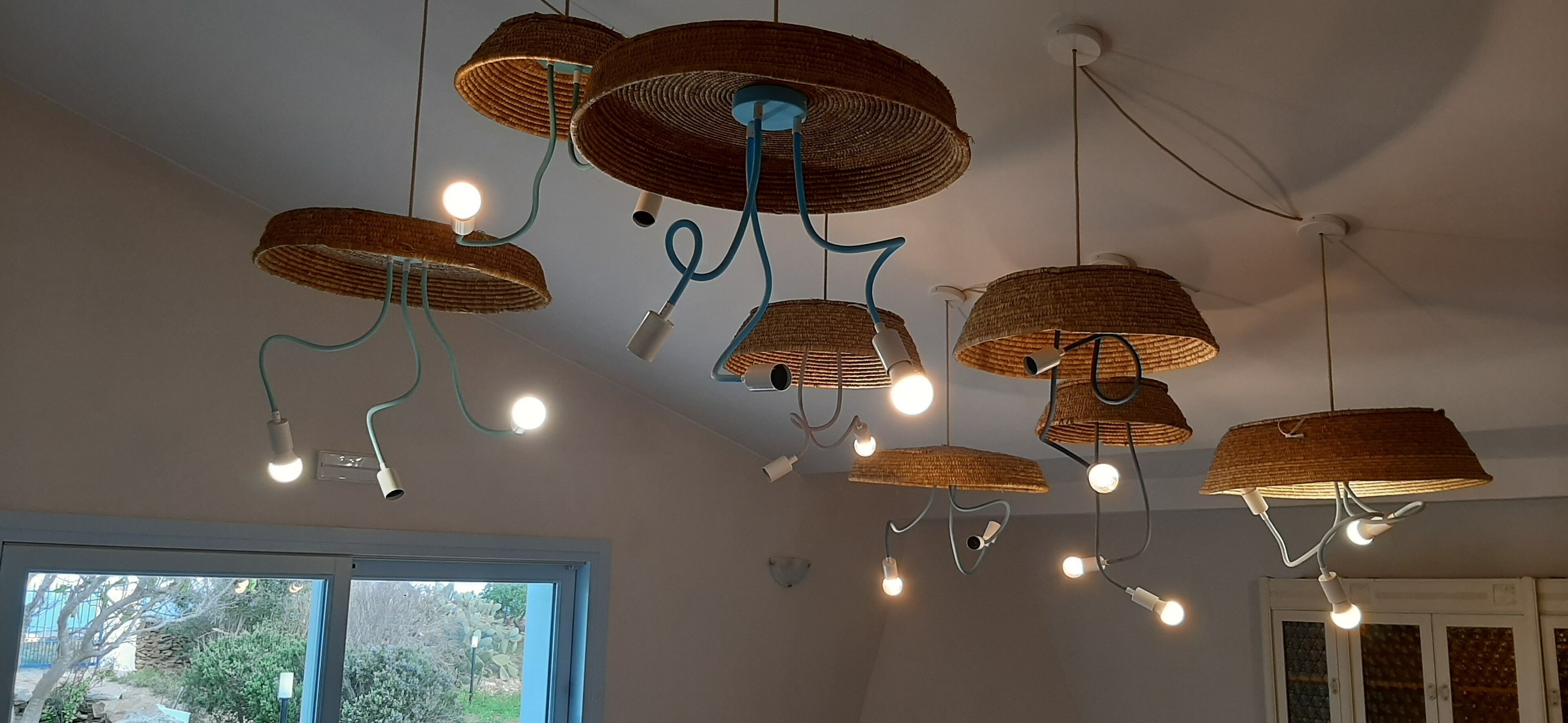 A ceiling with multiple wicker lampshades and exposed bulbs.
