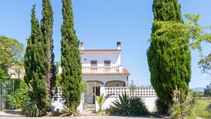 A two-story house with a tiled roof, a balcony, and a gated entrance. - "Holiday Home for 6 with Pool, BBQ, Wifi, Near Beach - Sant Pere Pescador, Costa Brava" (Sant Pere Pescador)