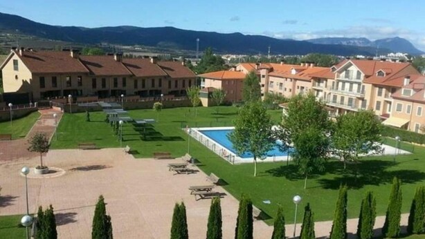 A residential area with multiple apartment buildings, a swimming pool, and well-maintained lawns. - Family-Friendly Apartment with Pool, Balcony, and Parking in Jaca (Jaca)