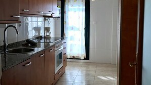 A kitchen with wooden cabinets, a stainless steel sink, and a coffee maker. - Family-Friendly Apartment with Pool, Balcony, and Parking in Jaca (Jaca)