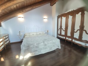 Cozy retreat with a large bed, wooden wardrobe, and ample natural light.
