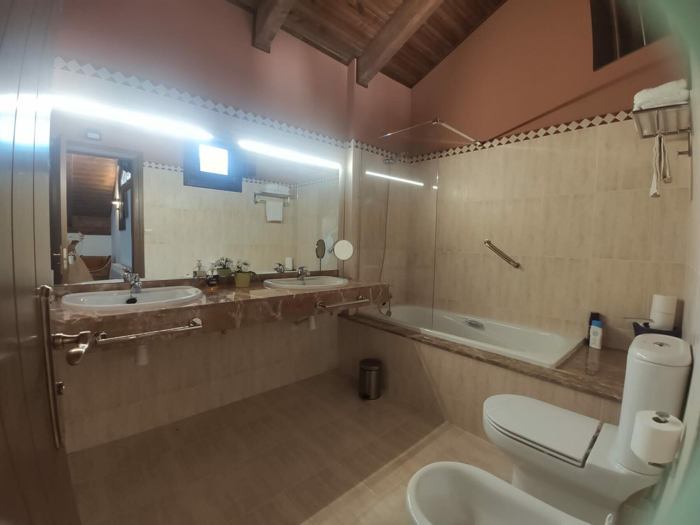 A bathroom with two sinks, a bathtub, and a toilet.