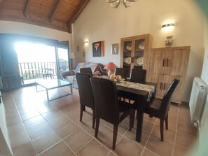 Relax in this inviting living area with a dining table for four, sofa, and large window offering a view of the outdoors.