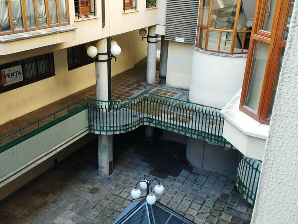 A multi-level building with a central staircase, metal railings, and a tiled floor.