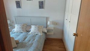Een slaapkamer met een bed, nachtkastjes en een kledingkast.