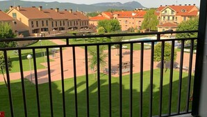 A balcony with a view of a courtyard, buildings, and distant mountains. - Spacious 2-Bed Apartment with Pool, Balcony & Garage in Jaca (Jaca)