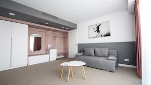 A modern living room with a grey sofa, a white coffee table, and a large painting on the wall. - Vila Sarisa (Deva)
