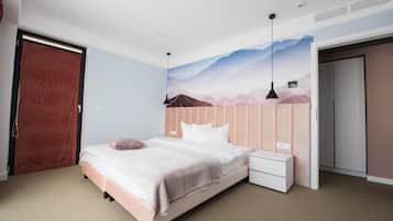 Un dormitorio con cama, mesita de noche y un mural en la pared.