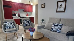 Un salon moderne avec un canapé gris, deux fauteuils et une table basse.