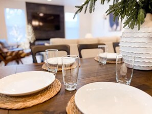 A dining table set with plates, glasses, and a decorative white cake.