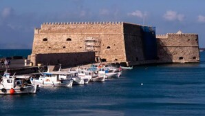A historic stone fortress with a moat, surrounded by calm water with several small boats docked. - CRETA GUEST HOUSE ARXONTIKO  15 min to golf club  and 15 minutes to the beach ! (Smari)