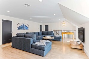 Una sala moderna con un sofá modular, una mesa de centro y una mesita auxiliar de madera.