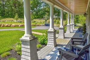 Un área de estar al aire libre cubierta con bancos de madera y columnas.