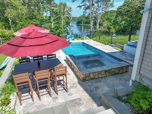 Ein Garten mit Schwimmbad, Whirlpool und Essbereich mit Tisch und Stühlen.
