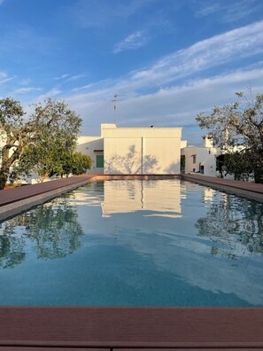 A clear swimming pool with a view of a building in the background. - Large Family-Friendly Villa with Trullo& private Pool in the Apulian Countryside (Puglia)