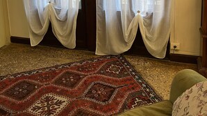 A room with a patterned carpet, a wooden door, and sheer curtains. - LIONS VENICE Guest House (Venice)