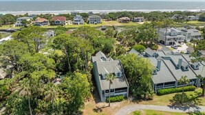 A coastal residential area with houses, dense greenery, and a view of the ocean. - 389 Wahoo Drive (Fripp Island)