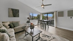 A modern living room with a sofa, coffee table, and dining area. - 1BA/1BA Miramar Beach, Inquire for Monthly Rates (Miramar Beach)