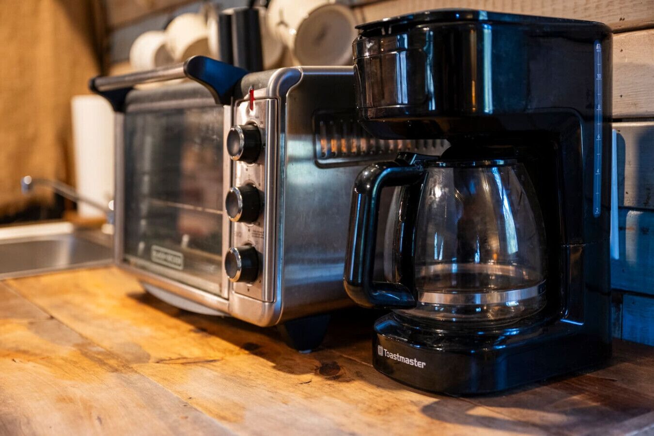 Un grille-pain et une machine à café sont posés sur un plan de travail en bois.