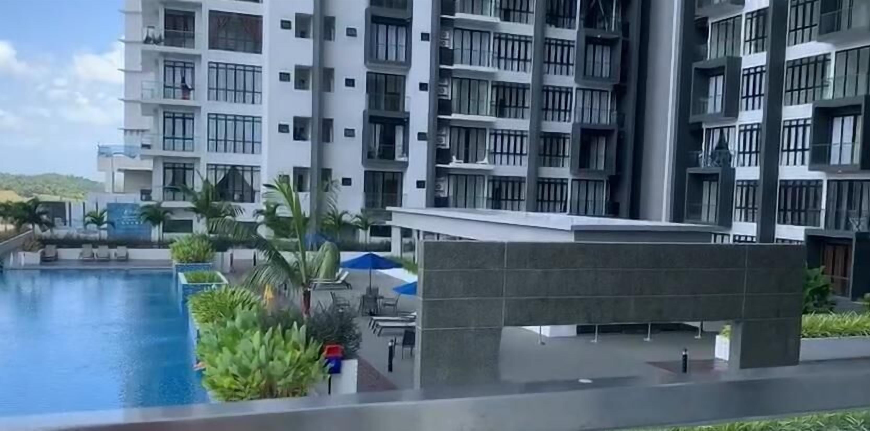 Un hotel moderno con piscina, mobiliario exterior y vistas a un paisaje montañoso.