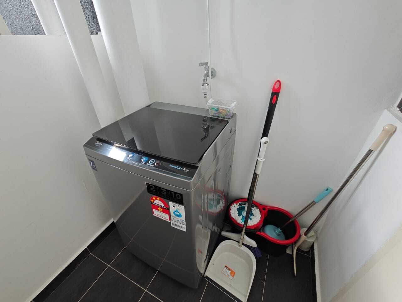 A compact kitchen with a built-in stove, a small sink, and cleaning tools.