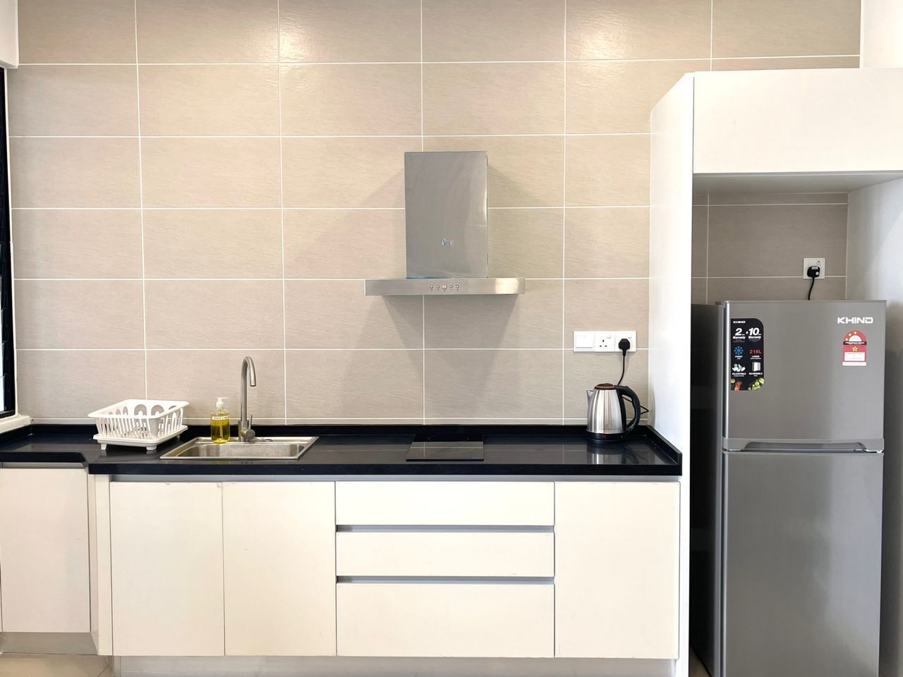 A modern kitchen with a stainless steel refrigerator, a built-in oven, and a gas stove.