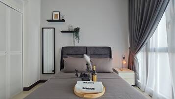 A modern bedroom with a large bed, a bedside table with a lamp, a mirror, and a shelf with decorative items.