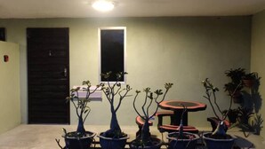 A small patio area with potted plants and a round table.