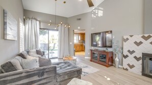 Een moderne woonkamer met een hoekbank, een televisie en een open haard.