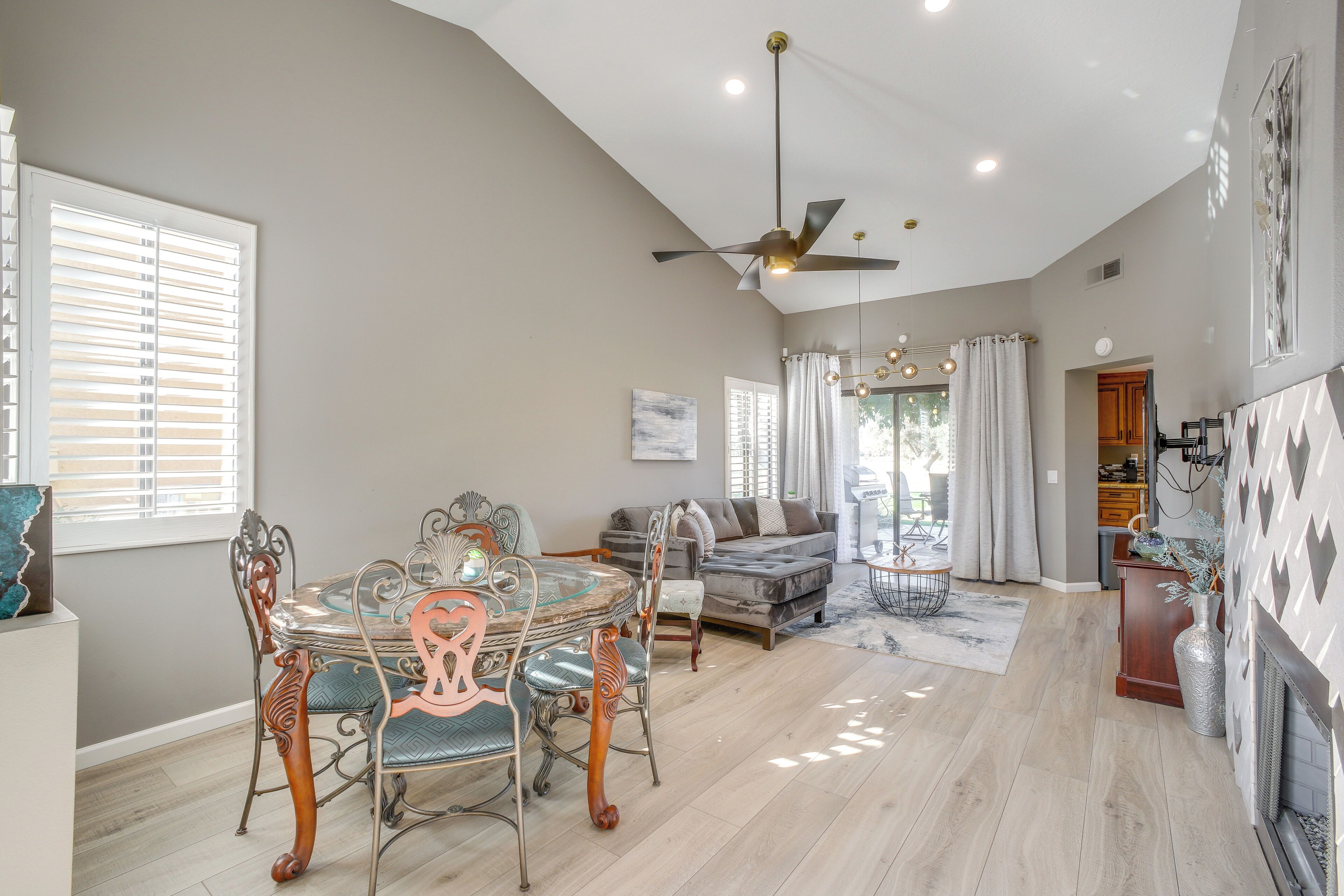 A spacious living area with a dining table, chairs, a sofa, and a fireplace.