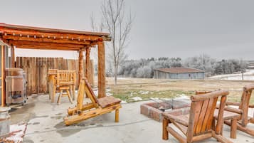 Relax on the patio surrounded by a rustic pergola and comfortable seating.