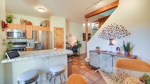 A modern kitchen with stainless steel appliances, wooden cabinets, and a central island with bar stools. - Bright Santa Fe Condo ~ Half-mi to Meow Wolf! (Santa Fe)