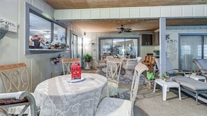 A dining area with a round table covered in lace, surrounded by wicker chairs, and a ceiling fan above. - Tampa Area Home w/ Indoor Pool, Families Welcome! (Brandon)