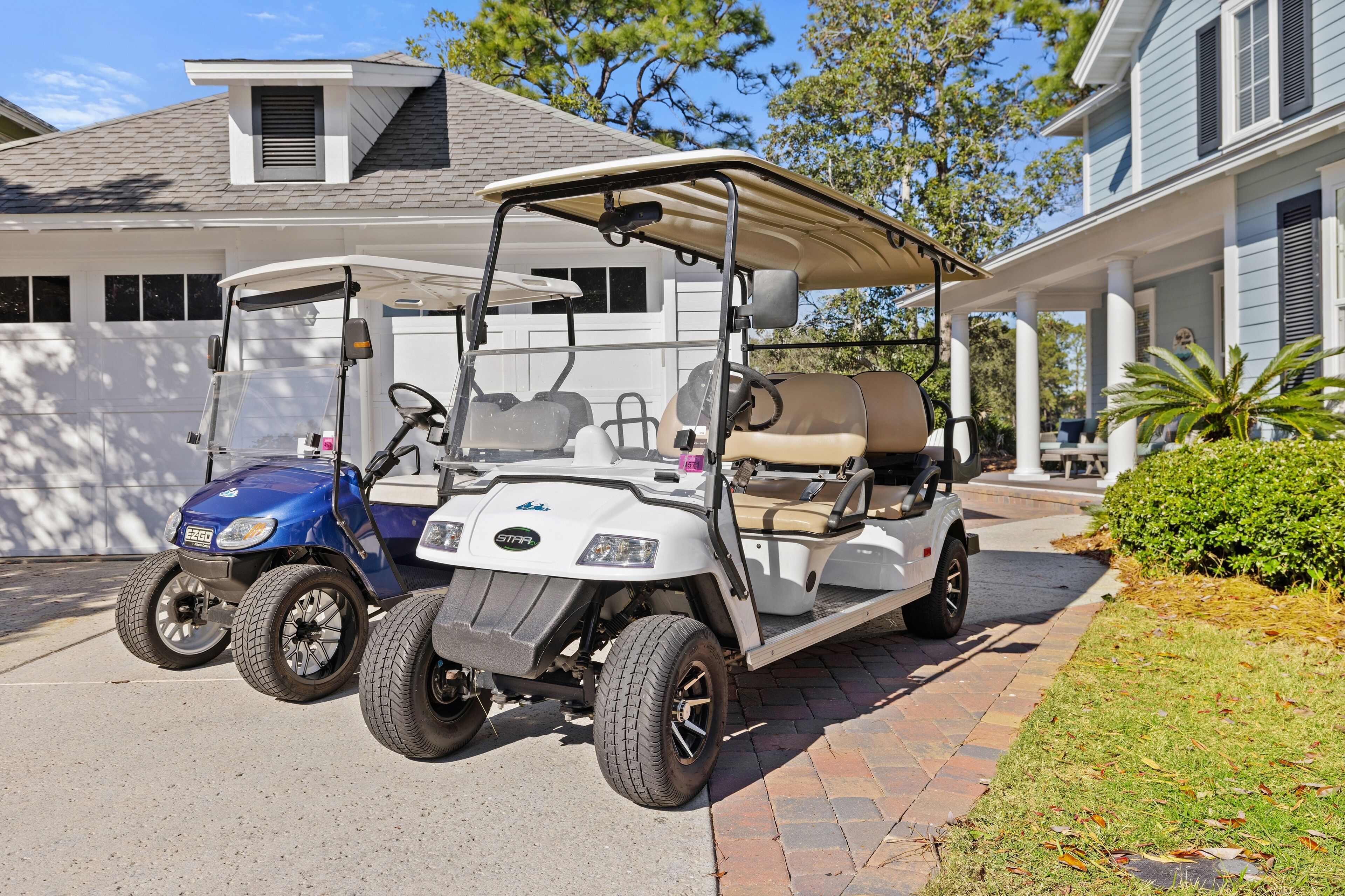 A golf cart parked in front of a house with a covered porch and a garage.