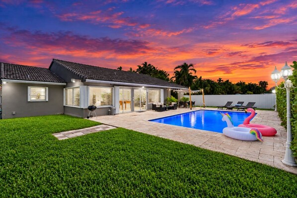Una propiedad residencial con piscina, zona de estar exterior y césped bien cuidado.