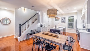 A spacious kitchen with a wooden dining table, black chairs, and a hanging light fixture. - LAKE FRONT~bonus room~GOLF CART~FREE Activites~Heated Pool* Hot tub (Miramar Beach)